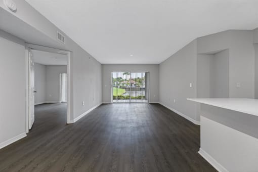 an empty living room with white walls and wood floors
