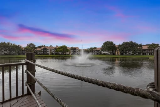 the fountain is in the middle of the pond at the preserve at sunset
