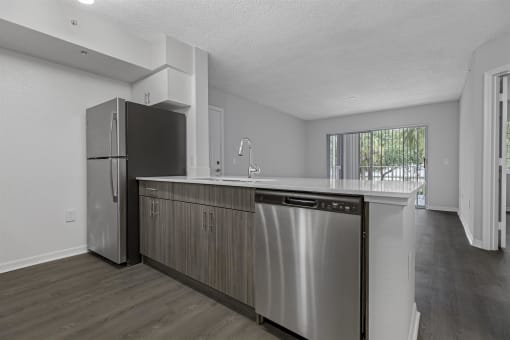 an empty kitchen with a stainless steel dishwasher and refrigerator