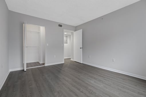an empty living room with wood floors and white walls