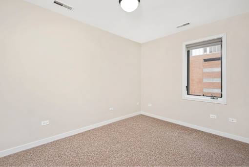 A room with a window and carpeted floor.