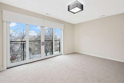 A room with a large window and sliding glass doors.