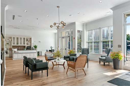 A modern living room with a kitchen in the background.