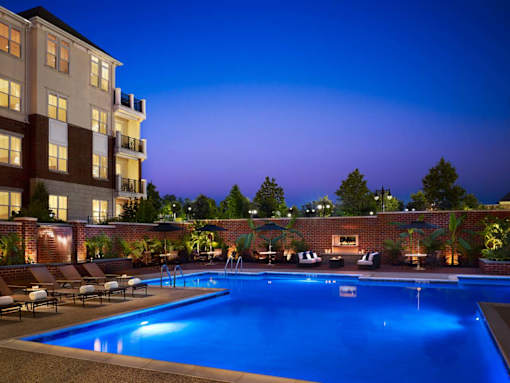 A swimming pool surrounded by lounge chairs and umbrellas at a hotel.