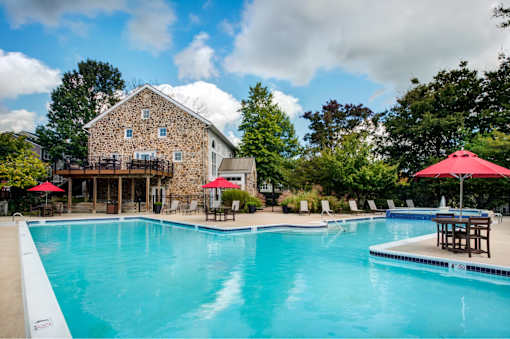 A large swimming pool with a house in the background.
