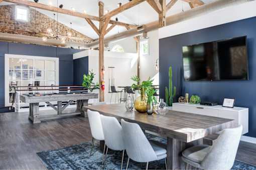 A dining room with a wooden table and chairs.