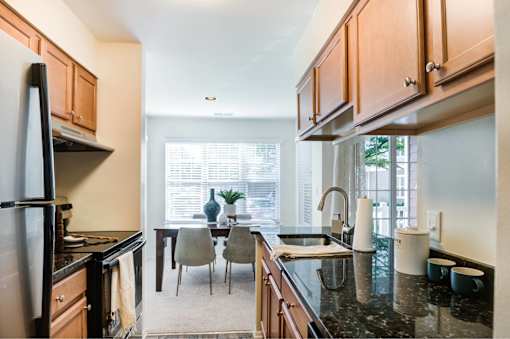 A kitchen with a black countertop and wooden cabinets.