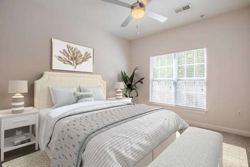 A bedroom with a bed, nightstands, and a ceiling fan.