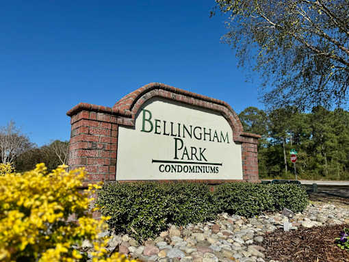 A sign for Bellingham Park Condominiums is shown in front of a blue sky.