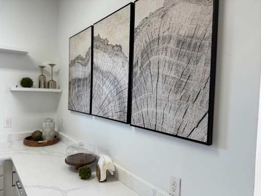 A large black and white artwork on a wall above a table.