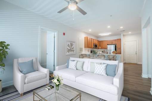 A living room with a white couch, two chairs, and a coffee table.