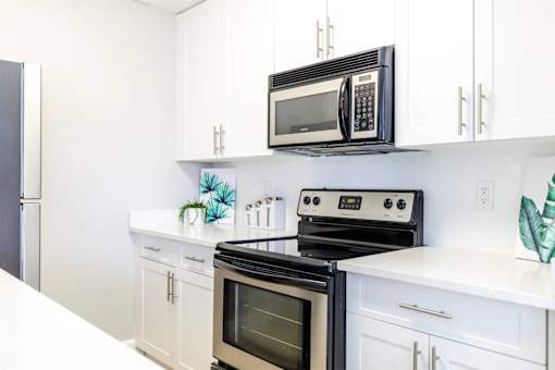 A black microwave oven is on top of a stove.