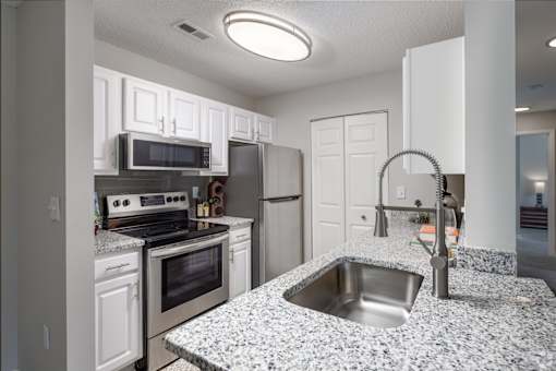 A kitchen with granite countertops and stainless steel appliances.