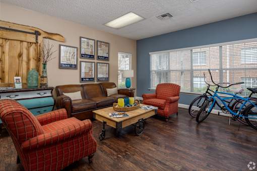 A living room with a brown couch, red chair, and a blue chair.