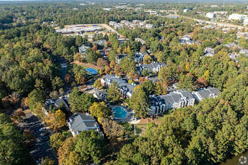 An aerial view of a residential area with houses surrounded by trees.