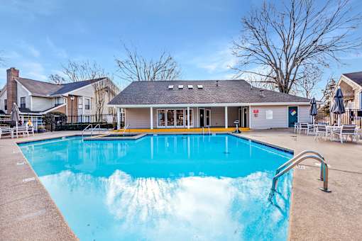 A large swimming pool in front of a building with a yellow line on the edge.