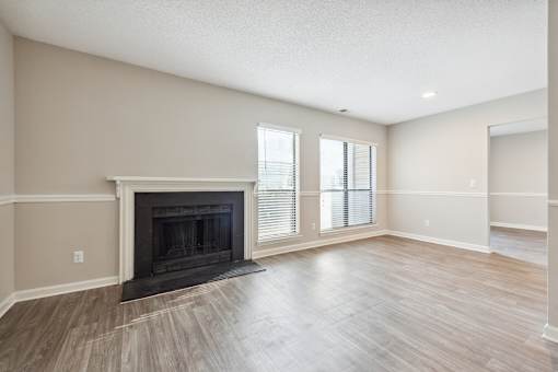 A living room with a fireplace and wood flooring.