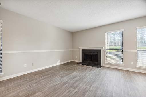 A room with a fireplace and wood flooring.