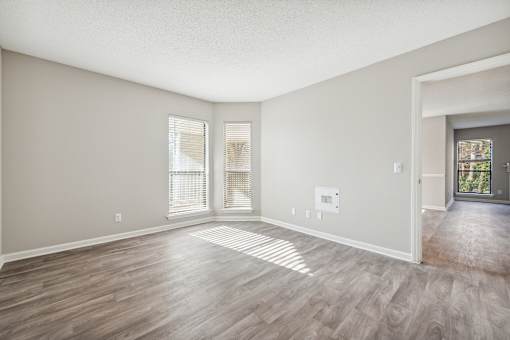 A room with wooden flooring and a door leading to a balcony.