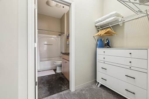 A white bathroom with a walk-in shower and a white cabinet with drawers.
