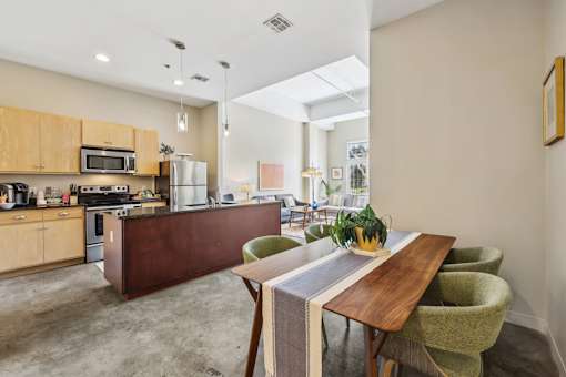 A kitchen with a table and chairs in the foreground and a refrigerator in the background.