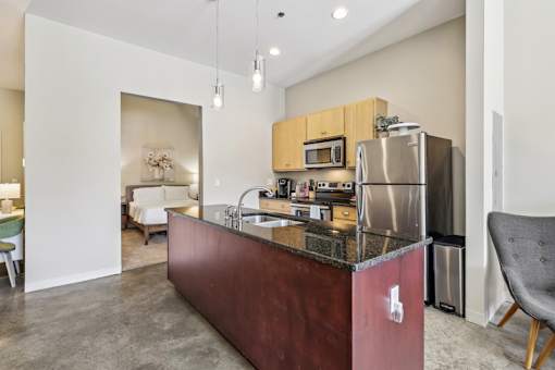 A kitchen with a granite countertop and stainless steel appliances.