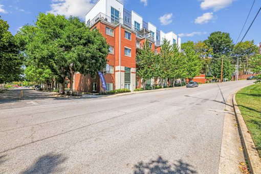 A street view of a residential area with a mix of modern and traditional buildings.