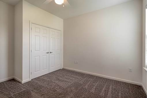 A room with a white door and carpeted floor.