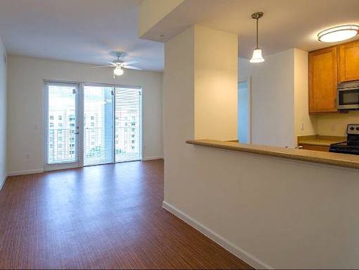 Open concept dining and living area with wood style flooring, ceiling fan and balcony door