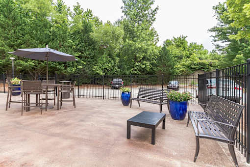 A patio with a table, chairs, and a bench.
