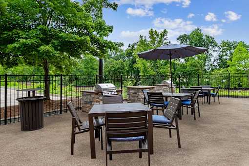 A patio with a table and chairs and an umbrella.