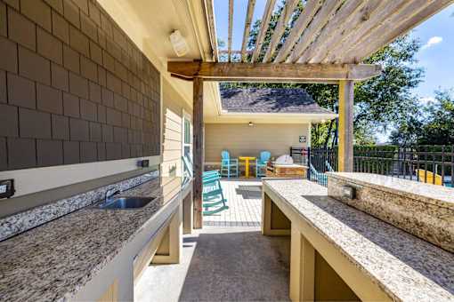 A kitchen with granite countertops and a wooden pergola.