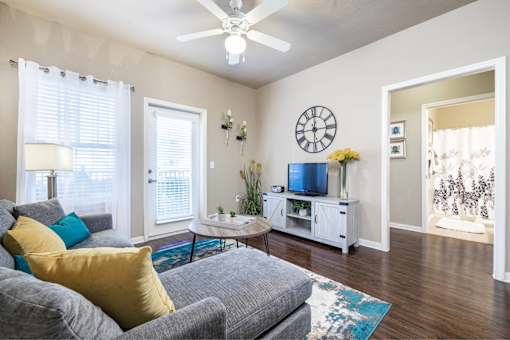 Big oaks apartments lakeland florida furnished model living room with ceiling fan, patio door