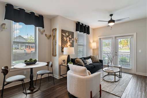 The Sound at Pennington Bend - Stylish Living Room With Modern Furniture, a Ceiling Fan, and Several Tall Windows with Blinds