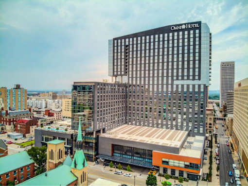 A modern hotel building is in the background of a cityscape.