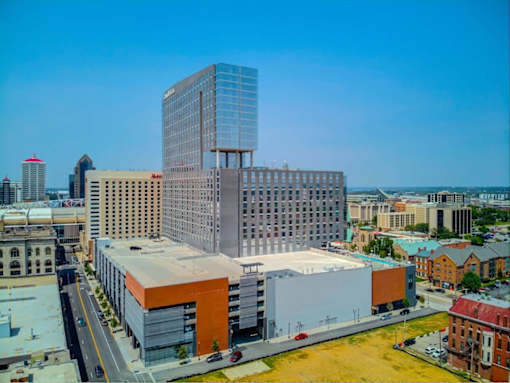 A modern glass building stands out in a cityscape.