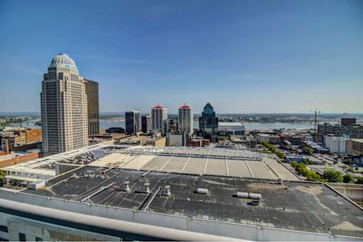 A cityscape with a large open parking lot in the foreground.