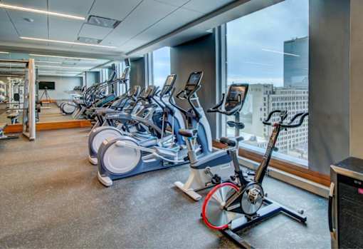 A gym with exercise bikes and a view of the city.
