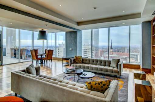A modern living room with a large window overlooking the city.