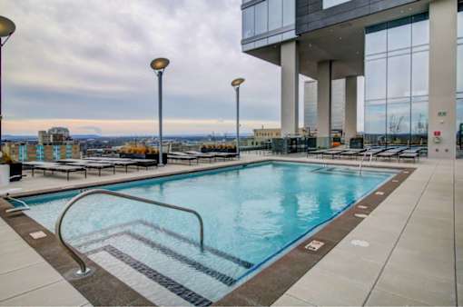 A large indoor swimming pool with a view of the city.