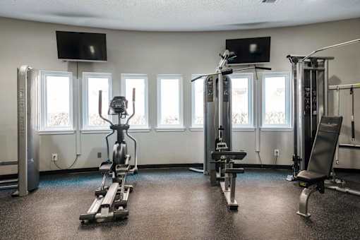 a gym with weights and a row of windows
