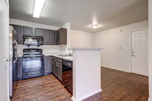 A kitchen with a white refrigerator and a black stove top oven.