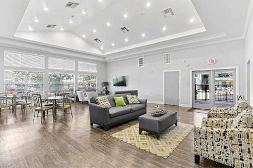 A living room with a grey couch and a yellow rug.