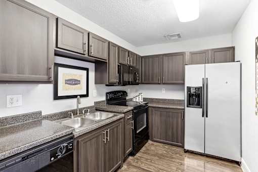 A kitchen with a white refrigerator and brown cabinets.