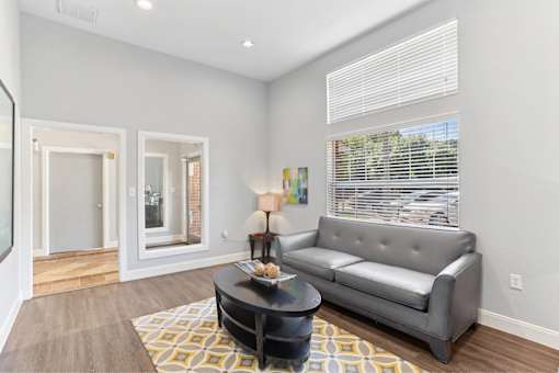 A grey couch sits in a living room with a coffee table in front of it.