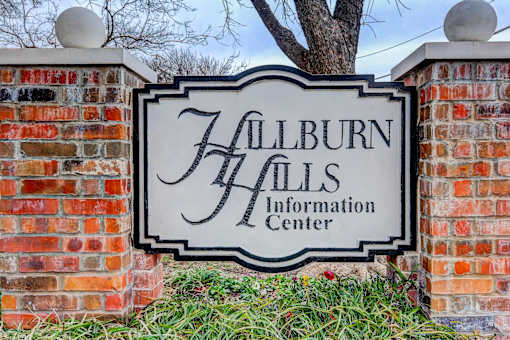 A sign that says "Hallburn Halls Information Center" is mounted on a brick wall.