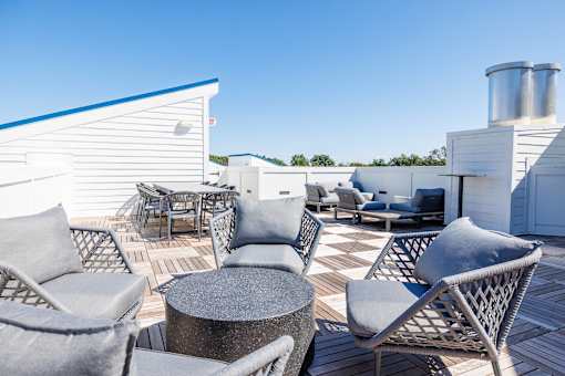 A patio with grey chairs and a table.