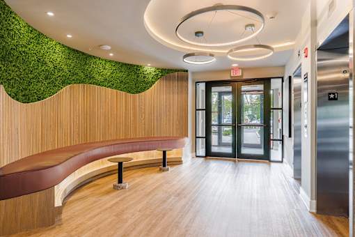 A hallway with a green wall and a bench.