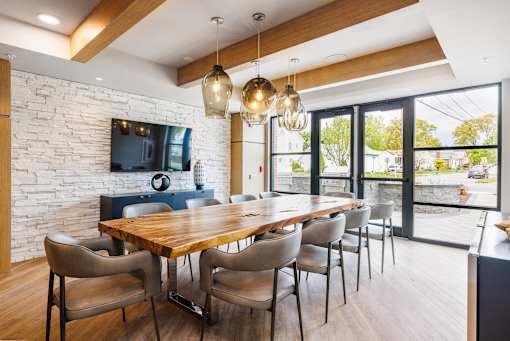 A dining room with a wooden table and chairs.