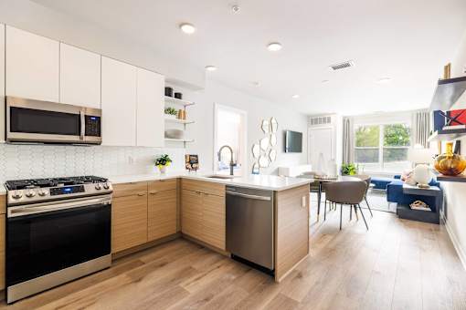 A modern kitchen with wooden cabinets and a stainless steel oven.